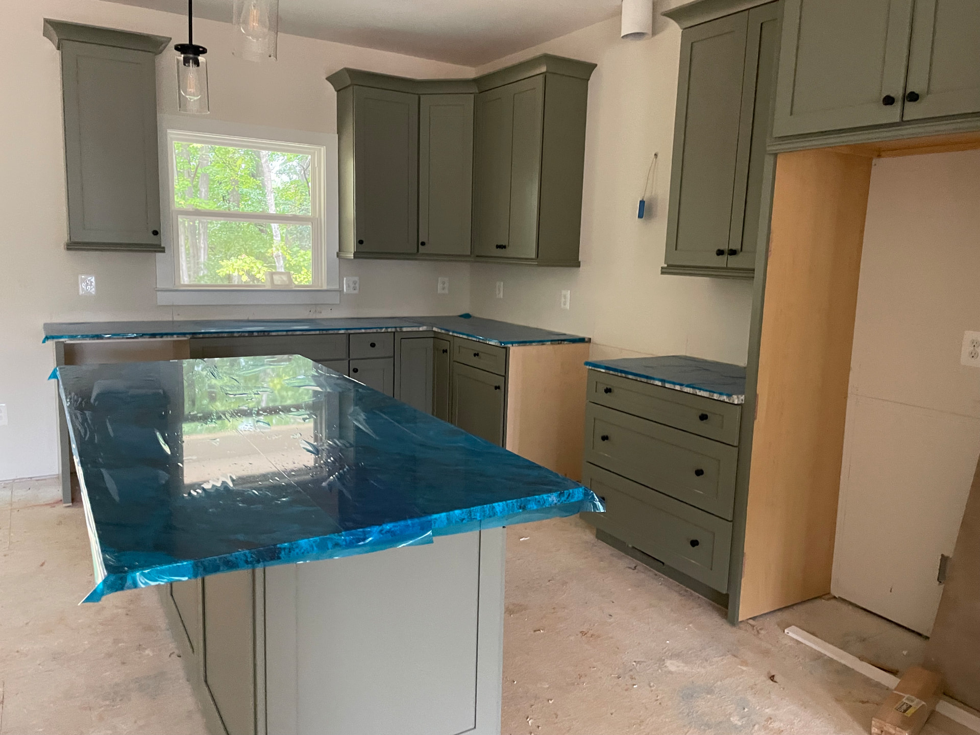 Installed kitchen cabinets with countertops covered at 8005 Sherbeyn Road